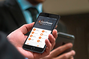 Hand holding mobile phone with SaskPower App on