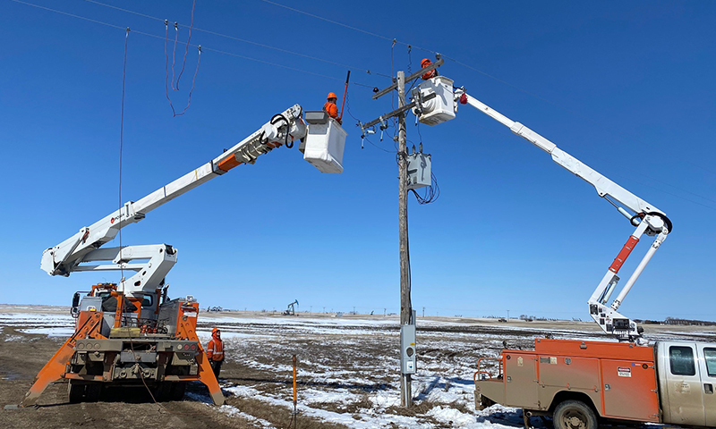 Two PLTs up in bucket trucks repairing a broken power line