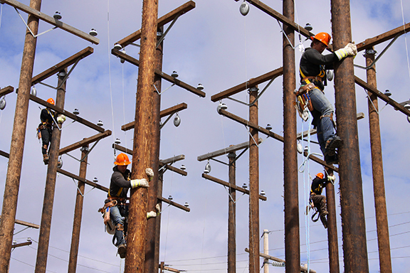 Linemen climbing poles